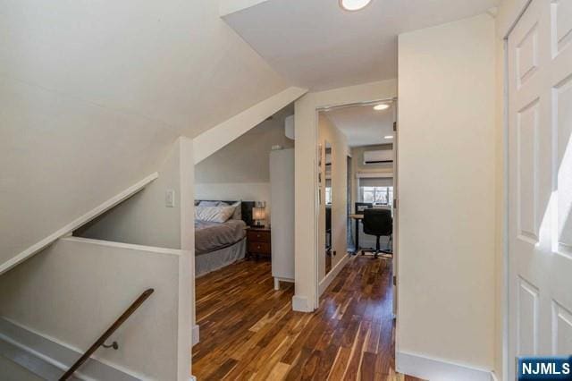 bedroom with a wall mounted air conditioner, lofted ceiling, dark wood-type flooring, and recessed lighting