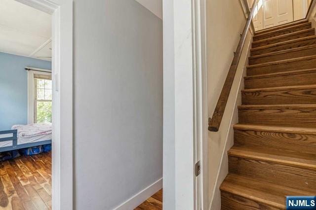 stairway with baseboards and wood finished floors