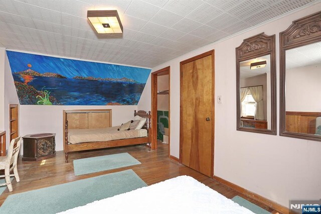 bedroom featuring wood finished floors and baseboards