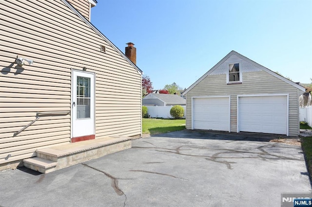 detached garage featuring fence