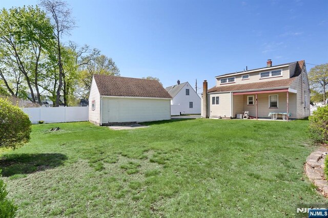 back of house with a chimney, fence, and a yard