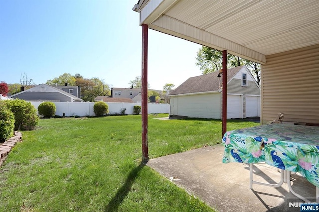 view of yard featuring an outdoor structure, a detached garage, a patio area, and fence