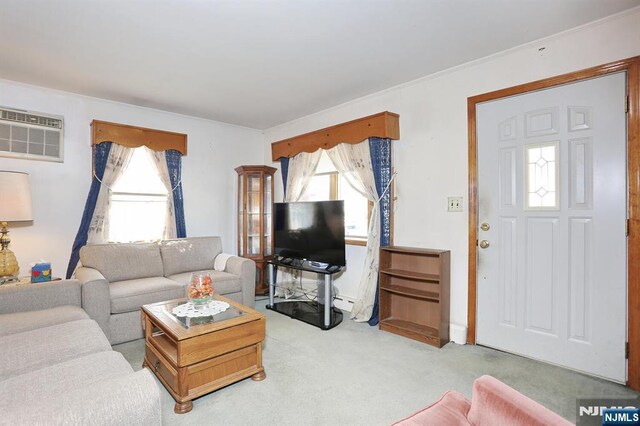 living area with an AC wall unit, a wealth of natural light, and light carpet