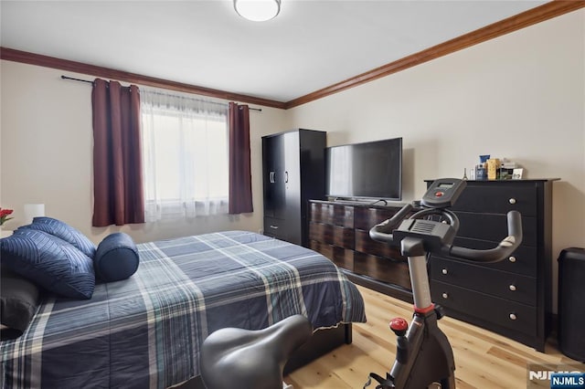 bedroom with crown molding and wood finished floors
