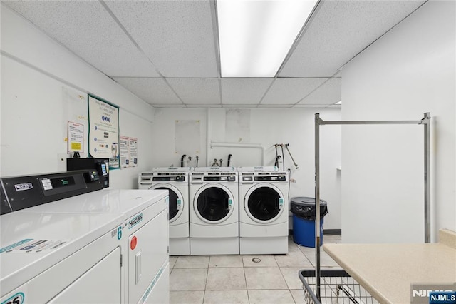 community laundry room featuring light tile patterned floors and washer and clothes dryer
