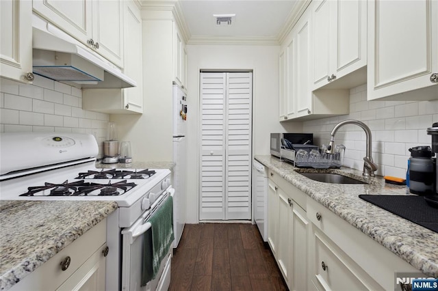 kitchen featuring a sink, under cabinet range hood, crown molding, visible vents, and white appliances