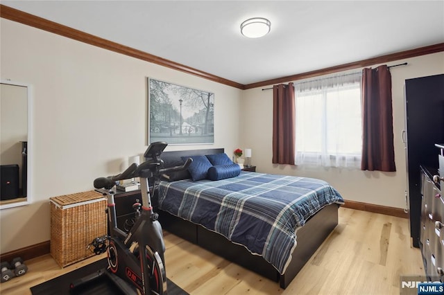 bedroom with light wood finished floors, ornamental molding, and baseboards