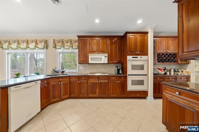 161 Winding Way, Old Tappan, NJ 07675 - kitchen featuring white appliances, ornamental molding, dark stone counters, decorative backsplash, and brown cabinets