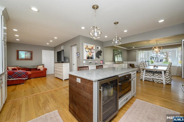 kitchen featuring beverage cooler, open floor plan, oven, and recessed lighting
