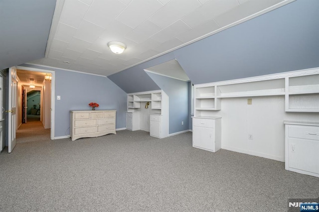 additional living space with baseboards, lofted ceiling, and carpet flooring