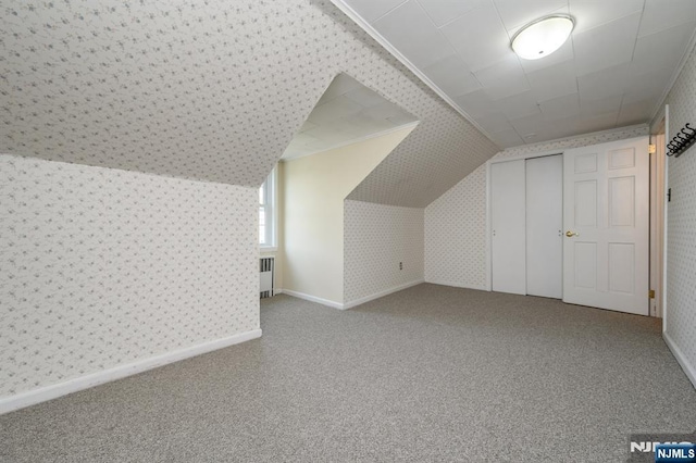 bonus room with wallpapered walls, radiator heating unit, and carpet flooring