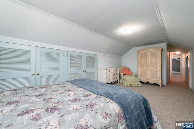 carpeted bedroom with lofted ceiling