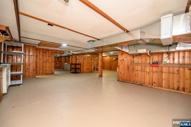 finished below grade area featuring tile patterned floors and wooden walls