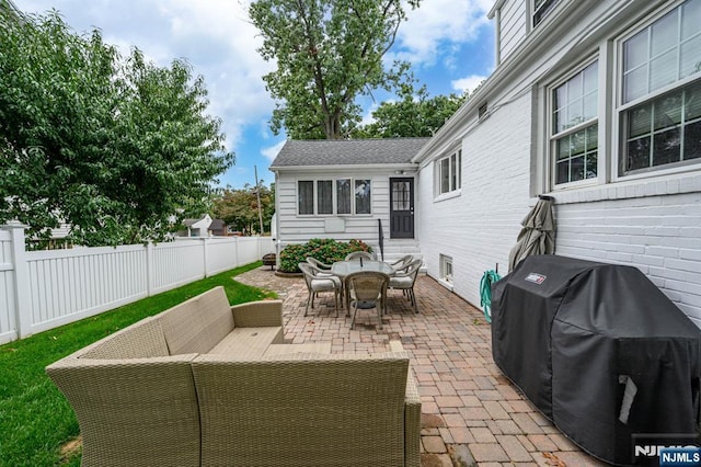 view of patio / terrace featuring a grill, outdoor dining area, an outdoor living space, and a fenced backyard