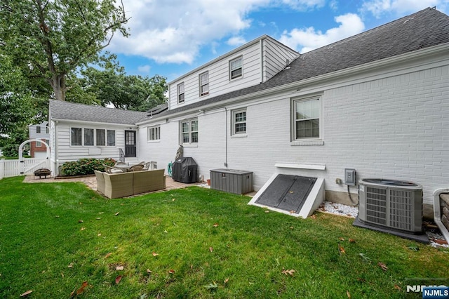 rear view of house featuring cooling unit, a lawn, roof with shingles, an outdoor hangout area, and fence
