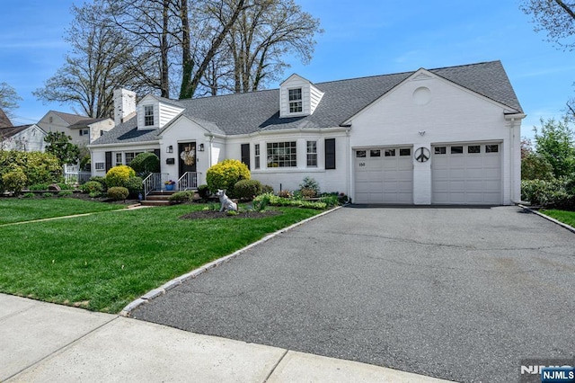 cape cod home with a front yard, brick siding, driveway, roof with shingles, and an attached garage