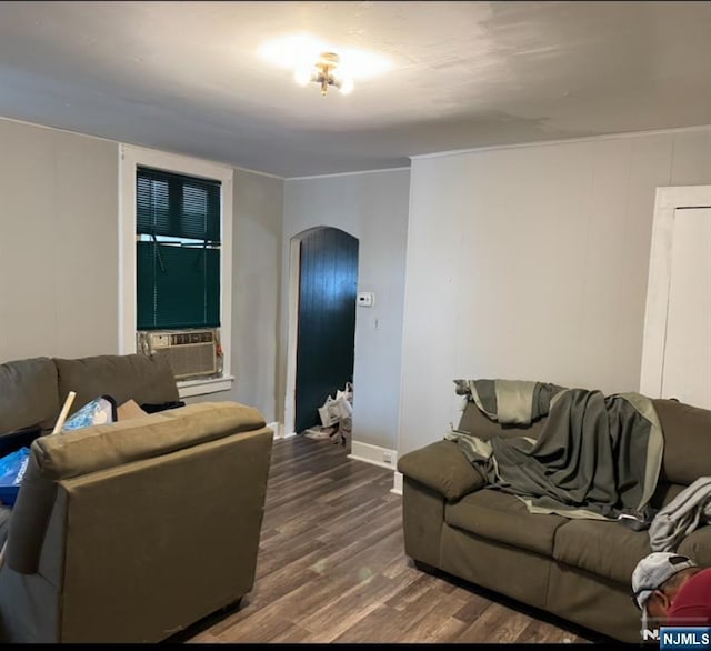 living area with baseboards, arched walkways, cooling unit, and wood finished floors