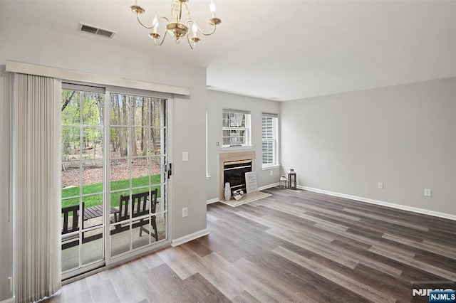2304 Wendover Dr, Pequannock Township, NJ 07444 - interior space with wood finished floors, an inviting chandelier, a glass covered fireplace, baseboards, and visible vents