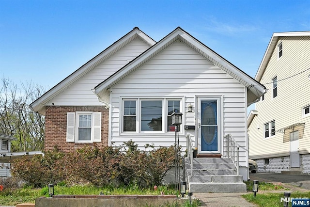 bungalow-style house with brick siding