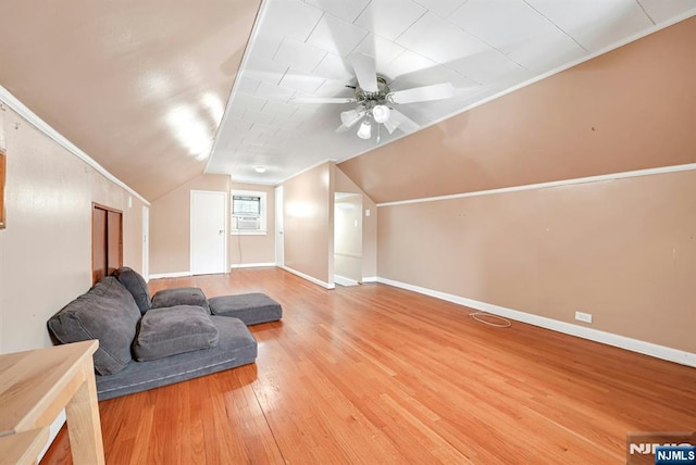 additional living space featuring a ceiling fan, lofted ceiling, wood finished floors, and baseboards