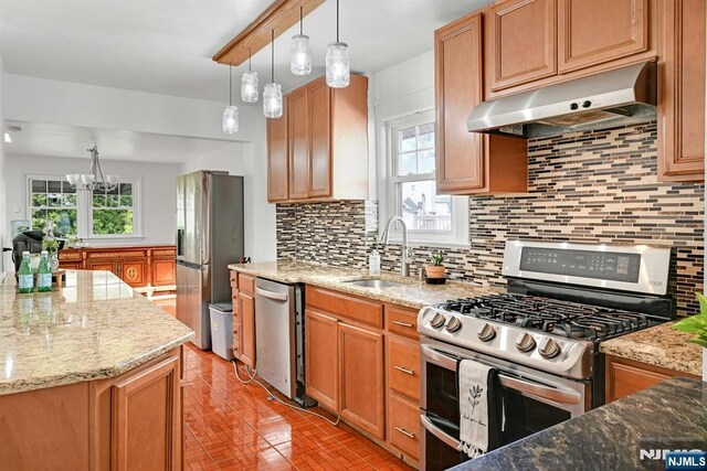 kitchen featuring a sink, decorative backsplash, stainless steel appliances, under cabinet range hood, and light stone counters
