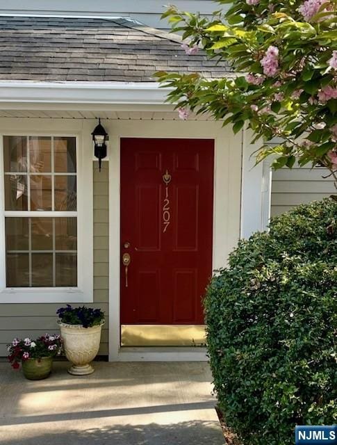 property entrance with a shingled roof