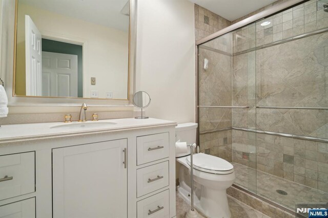 full bath featuring vanity, toilet, and a stall shower