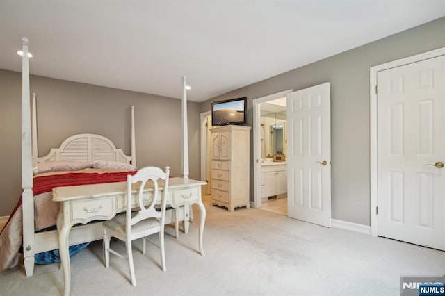 bedroom with light colored carpet, connected bathroom, and baseboards