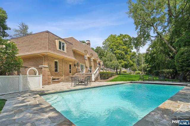 view of swimming pool with fence, a fenced in pool, and a patio area