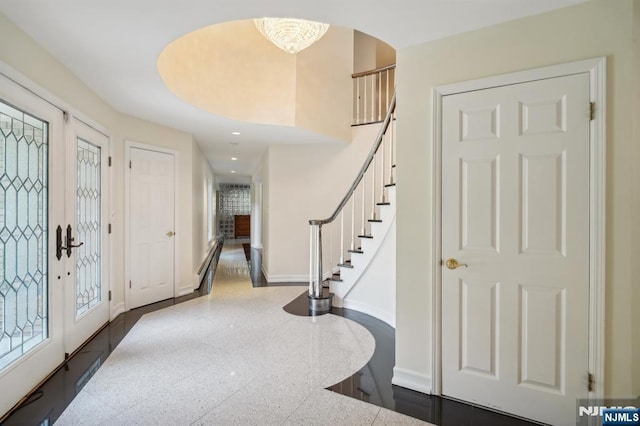 entrance foyer with recessed lighting, granite finish floor, stairs, baseboards, and arched walkways