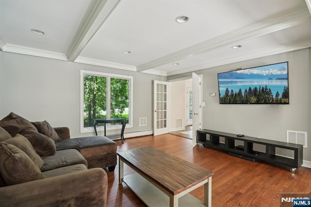 living area with ornamental molding, beamed ceiling, visible vents, and wood finished floors