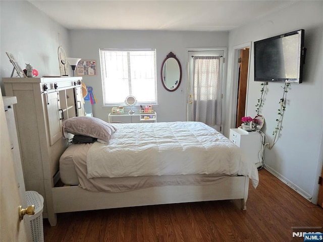 bedroom with wood finished floors and baseboards