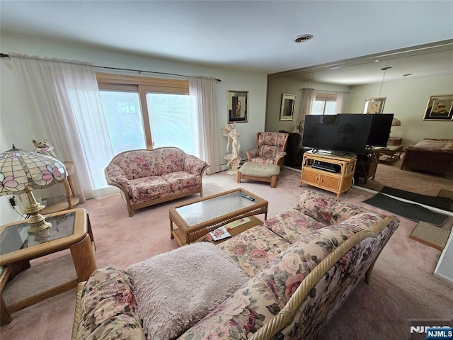 living area with visible vents and carpet