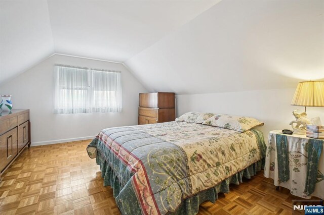 bedroom with vaulted ceiling and baseboards