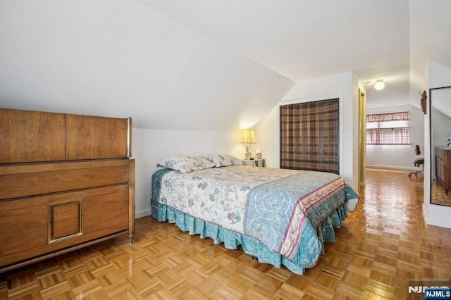 bedroom featuring lofted ceiling and baseboards