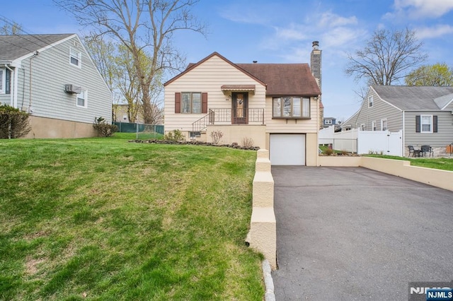 bungalow-style house with fence, a chimney, driveway, and a front yard