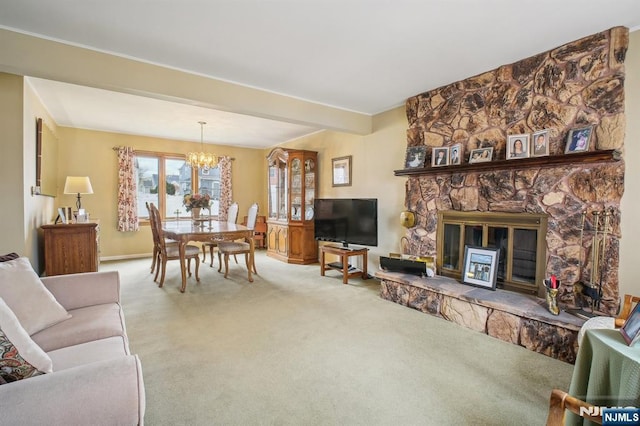carpeted living room featuring a fireplace, a notable chandelier, and baseboards