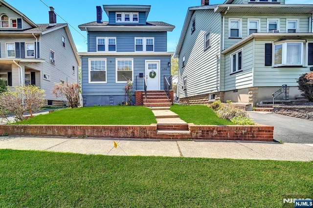 american foursquare style home featuring a front yard