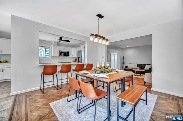 dining room with a healthy amount of sunlight, ceiling fan, and baseboards