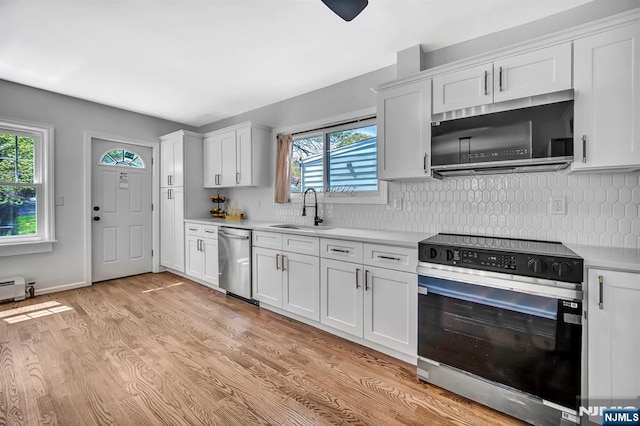 kitchen featuring a sink, a wealth of natural light, stainless steel appliances, and light countertops
