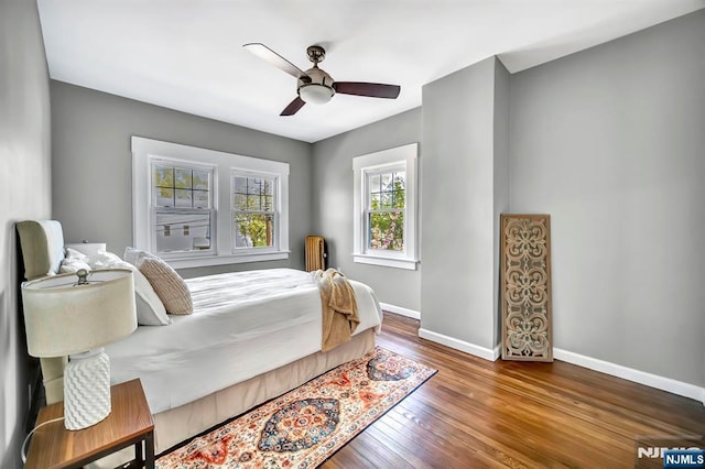 bedroom featuring a ceiling fan, wood finished floors, and baseboards