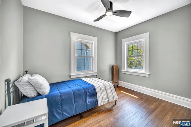 bedroom with baseboards, wood finished floors, and a ceiling fan