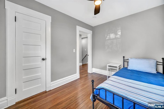 bedroom featuring a ceiling fan, wood finished floors, and baseboards