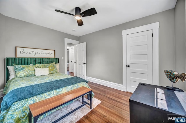 bedroom featuring a ceiling fan, wood finished floors, and baseboards