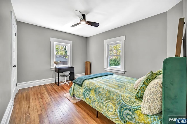bedroom featuring wood-type flooring, ceiling fan, and baseboards
