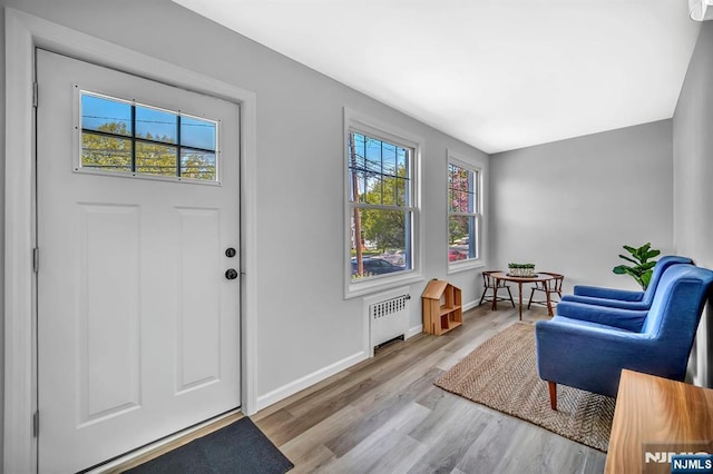 entryway featuring radiator, wood finished floors, and baseboards