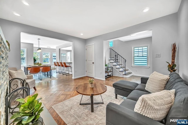 living area featuring a healthy amount of sunlight, baseboards, recessed lighting, and stairs