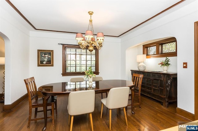 dining area with a chandelier, baseboards, arched walkways, and wood finished floors