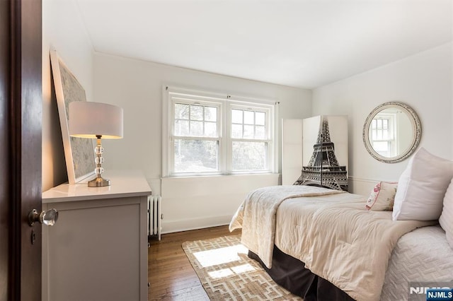 bedroom featuring hardwood / wood-style floors and radiator