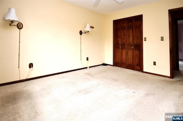 unfurnished bedroom featuring carpet floors, baseboards, a ceiling fan, and a closet